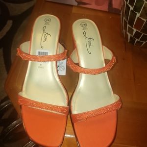 Orange strappy sandals with gemstones.